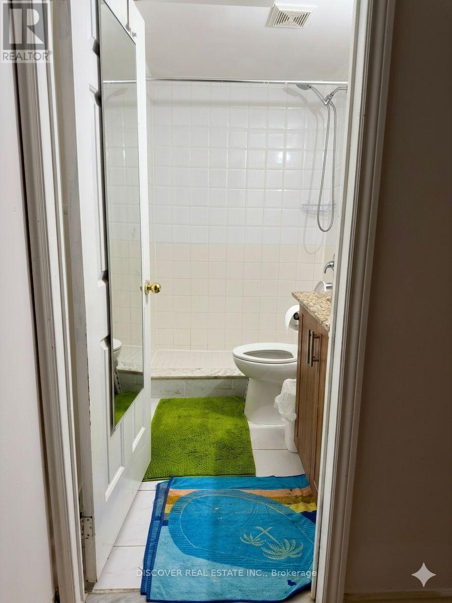 A bathroom with a toilet, sink and shower.