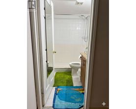 A bathroom with a toilet, sink and shower.