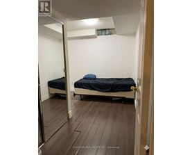 A bedroom with a bed and a mirror on the wall.