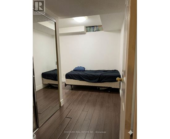 A bedroom with a bed and a mirror on the wall.