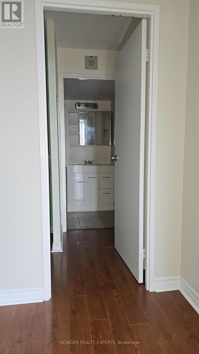A hallway with a white door leading to a bedroom.