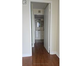 A hallway with a white door leading to a bedroom.