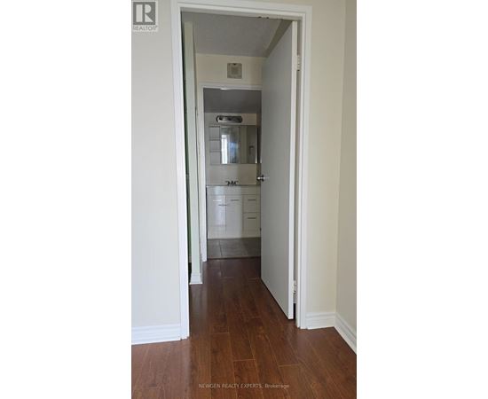 A hallway with a white door leading to a bedroom.
