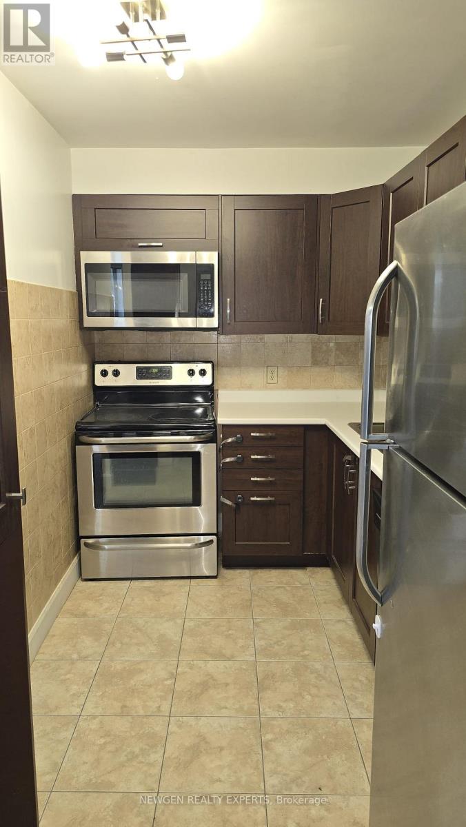 A kitchen with a stove top oven, microwave, and refrigerator.
