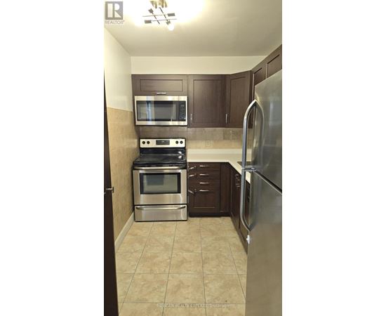 A kitchen with a stove top oven, microwave, and refrigerator.