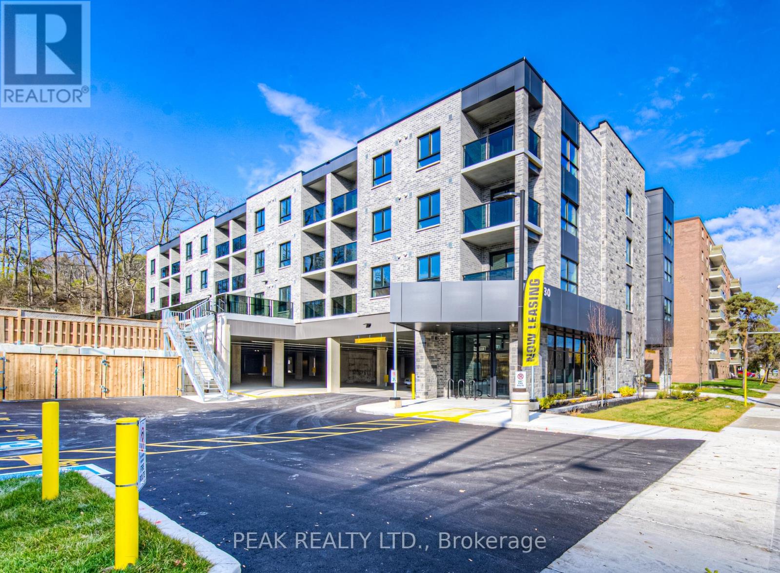 A modern apartment building with a parking lot in front.