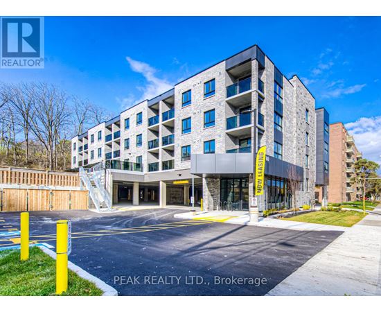 A modern apartment building with a parking lot in front.
