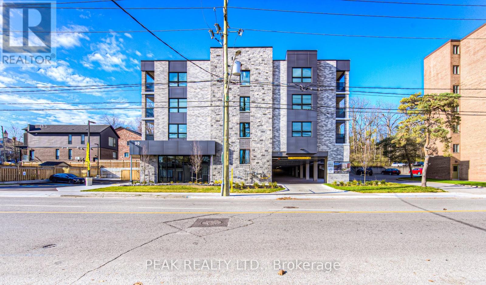 A building with the sign "Peak Realty LTD Brokerage" in front of it.