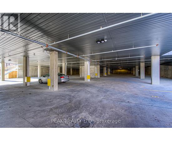 A spacious, empty parking garage with a car parked in the middle.