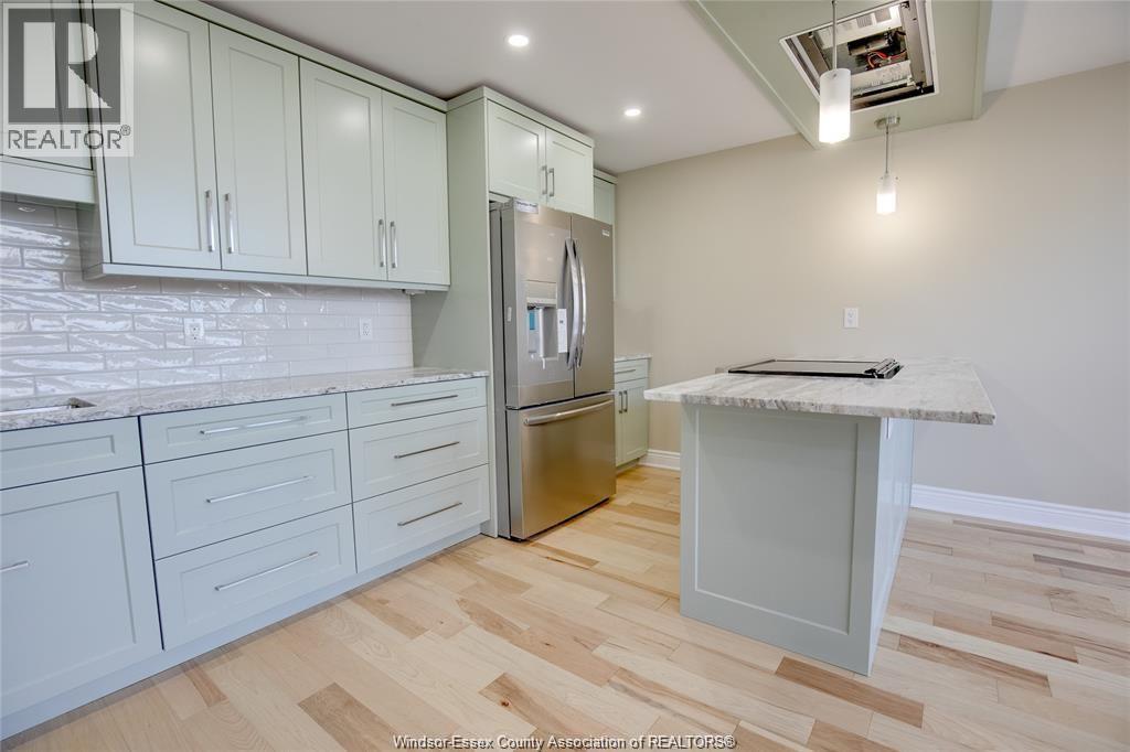 A kitchen with white cabinets and a wooden floor.