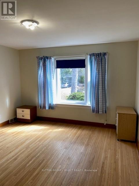A room with a window and a wooden floor.