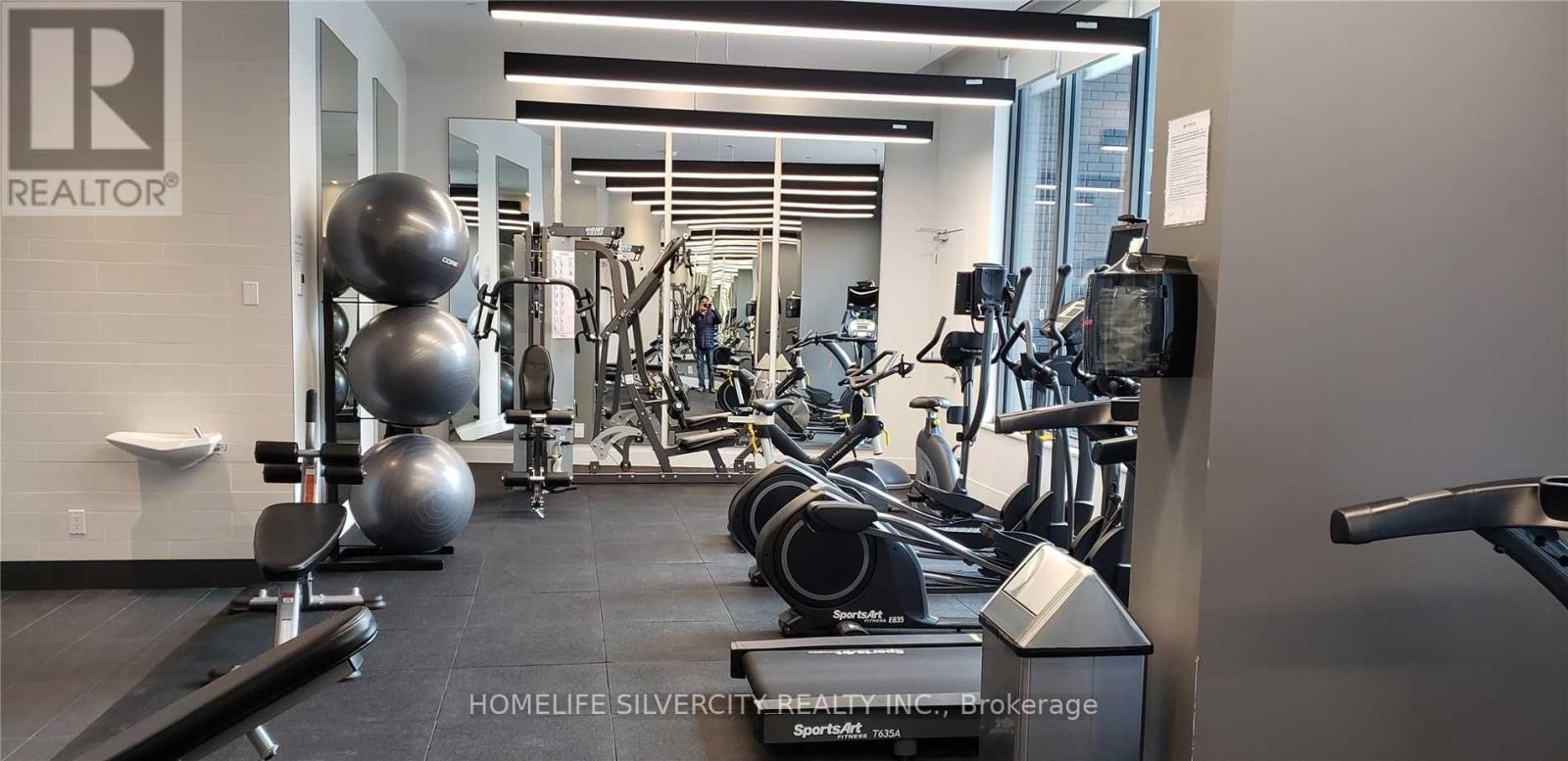 A gym with a variety of equipment including treadmills, weights and exercise machines.
