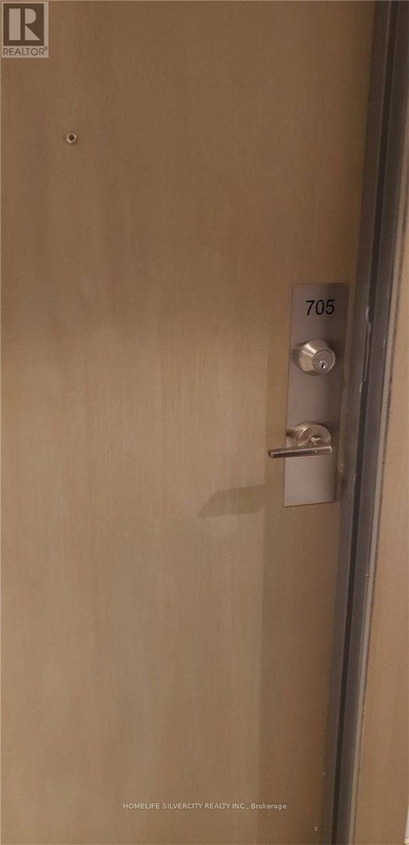 A door with a handle and a sign that says 705.