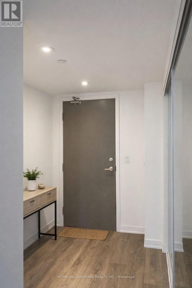 A room with a brown door and a small table with a plant on it.