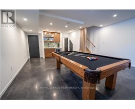A pool table in a room with a leopard print skirt on it.