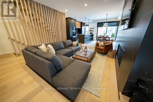 A modern living room with a grey sofa and a wooden wall panel.