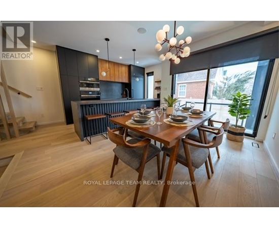 A dining room with a wooden table and chairs.