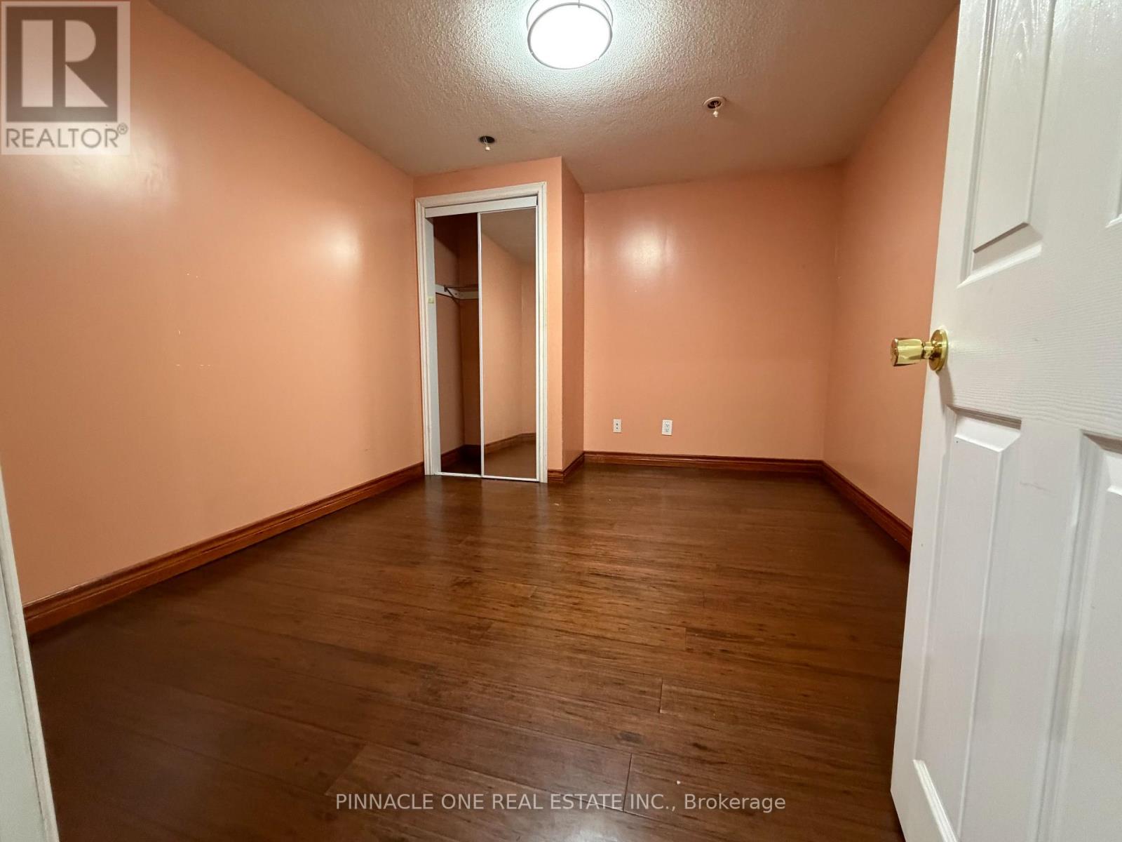 A room with a white door and a wooden floor.