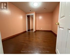 A room with a white door and a wooden floor.