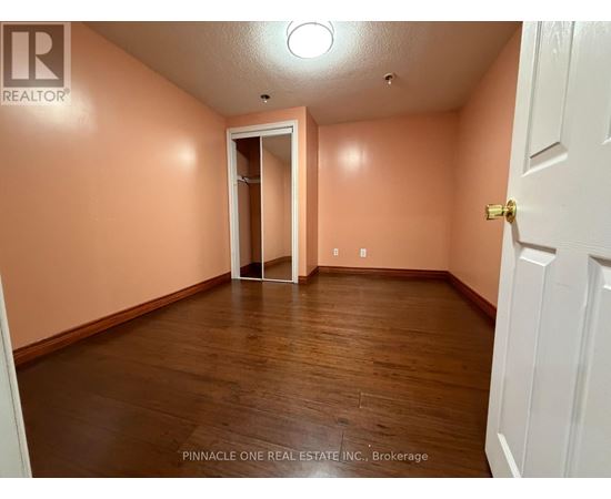 A room with a white door and a wooden floor.
