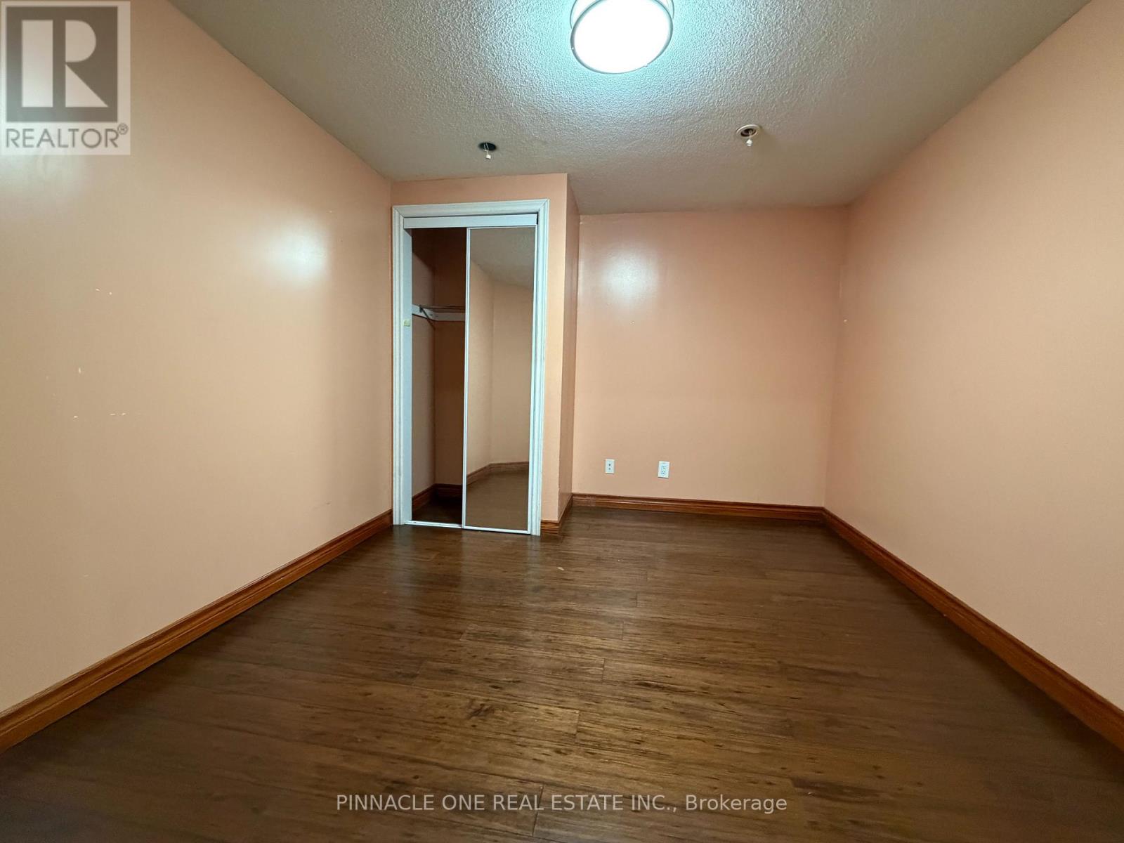 A room with a wooden floor and a white door.