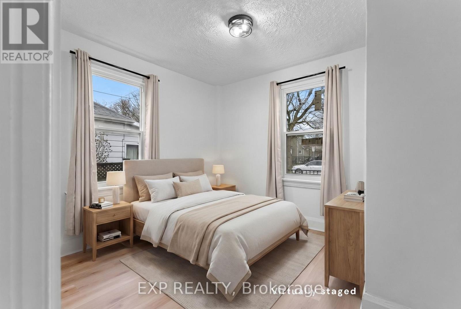 A bedroom with a large bed, nightstands, and a window with curtains.