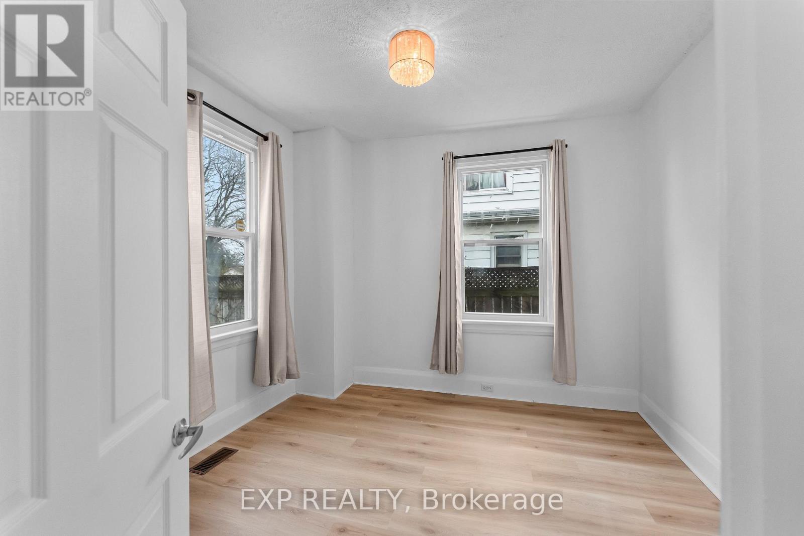 A room with a door and a window with a view of trees.