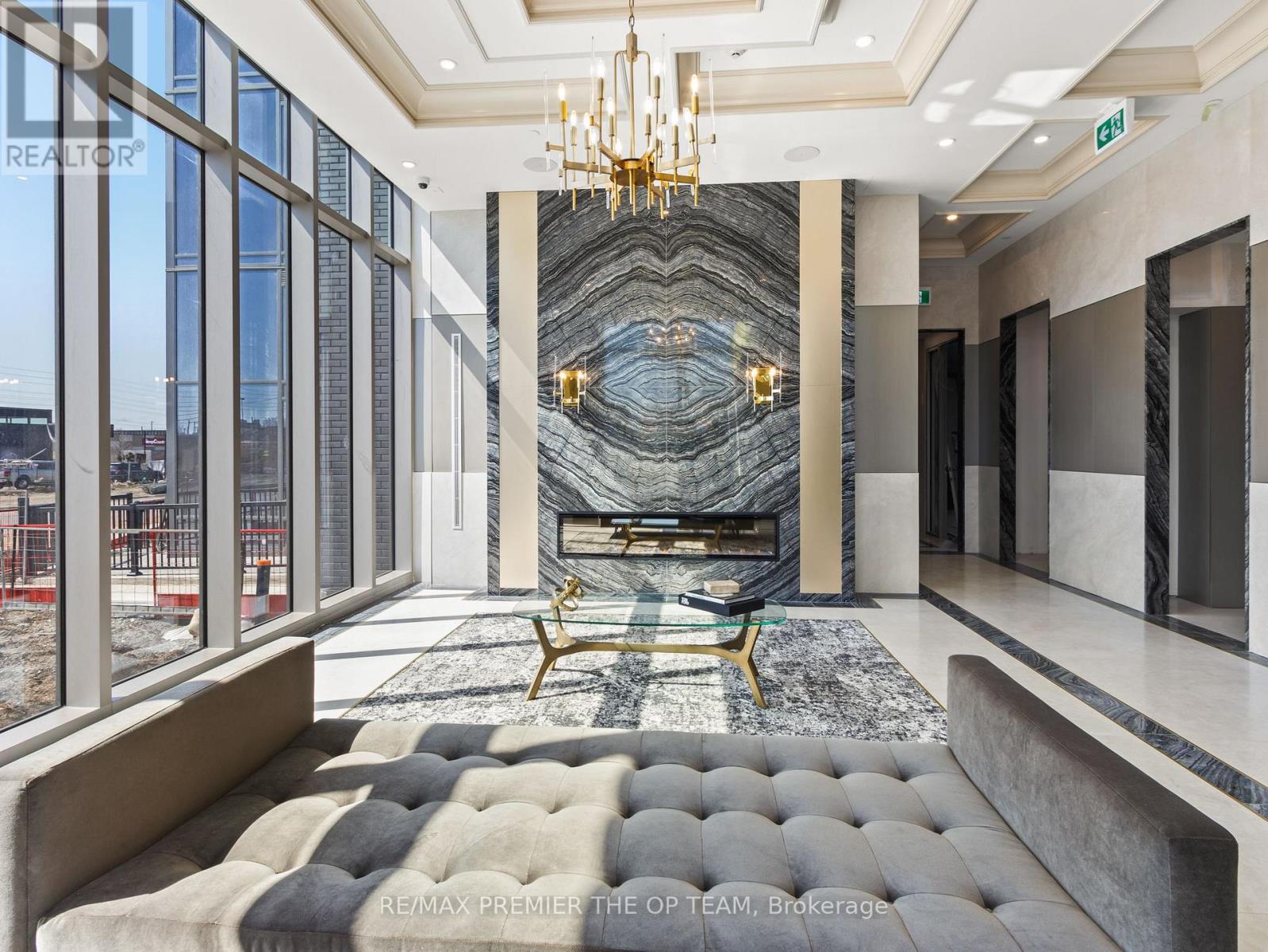 A large, modern living room with a marble staircase and a chandelier.