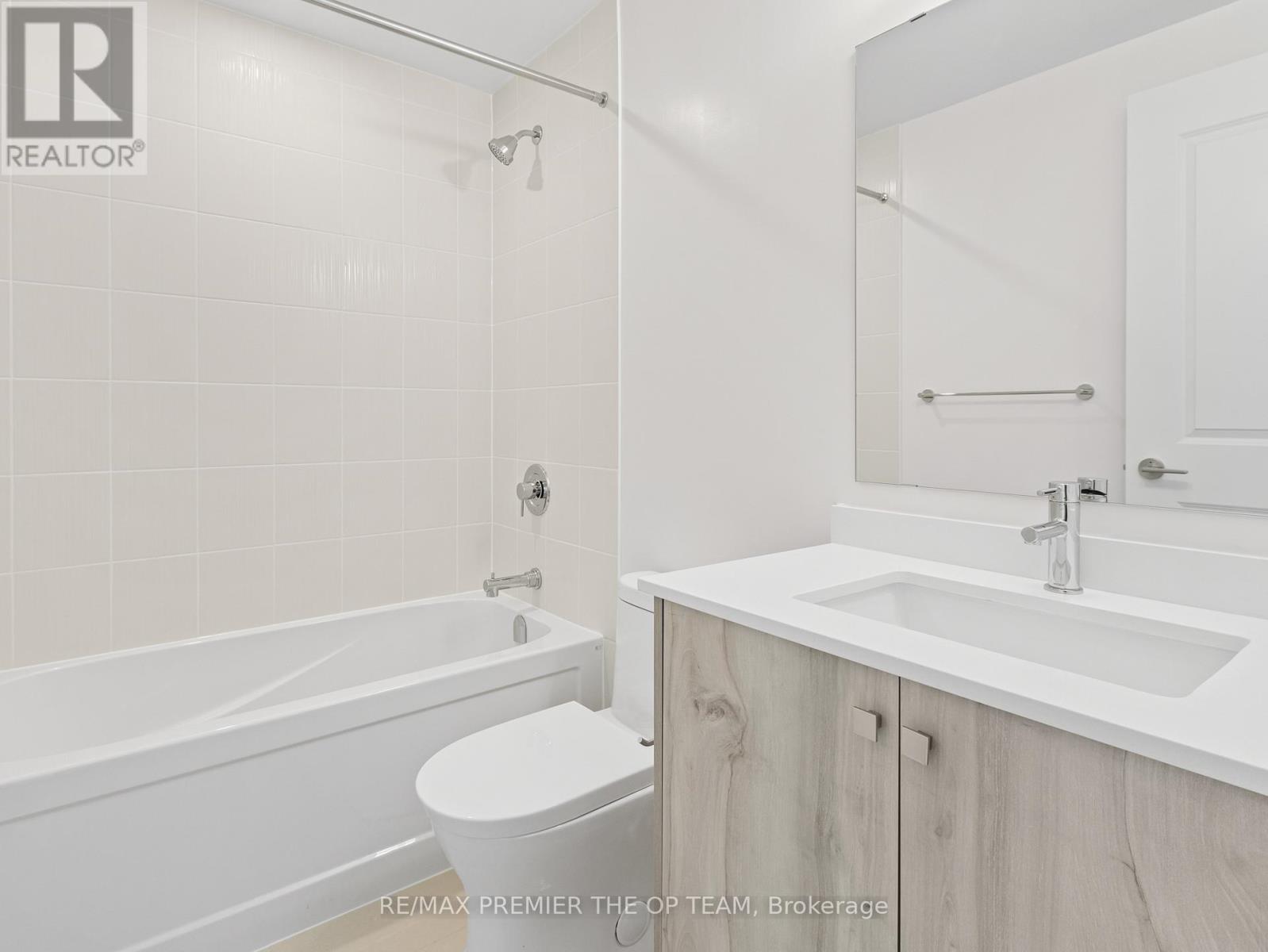 A white bathroom with a toilet, sink, and bathtub.