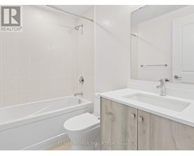 A white bathroom with a toilet, sink, and bathtub.
