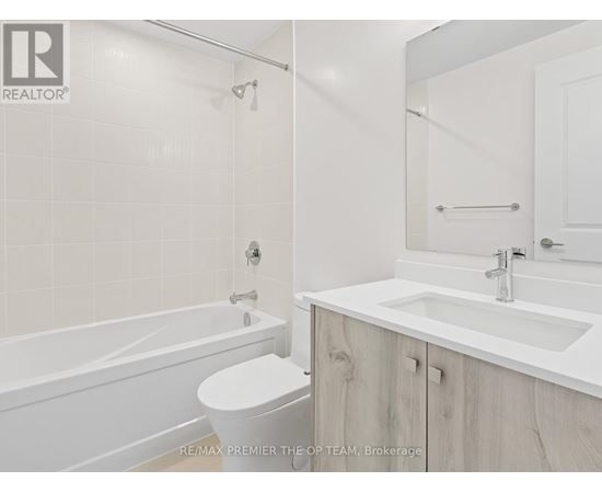 A white bathroom with a toilet, sink, and bathtub.