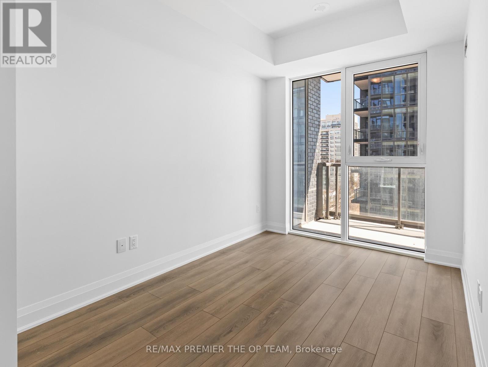 A room with a view of a cityscape through a glass door.