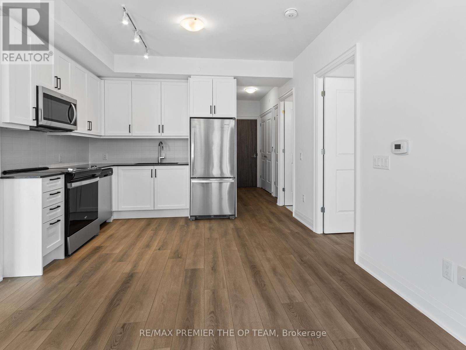 A kitchen with white cabinets and a wooden floor.