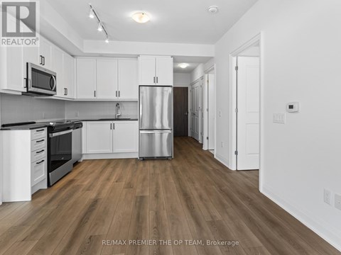 A kitchen with white cabinets and a wooden floor.
