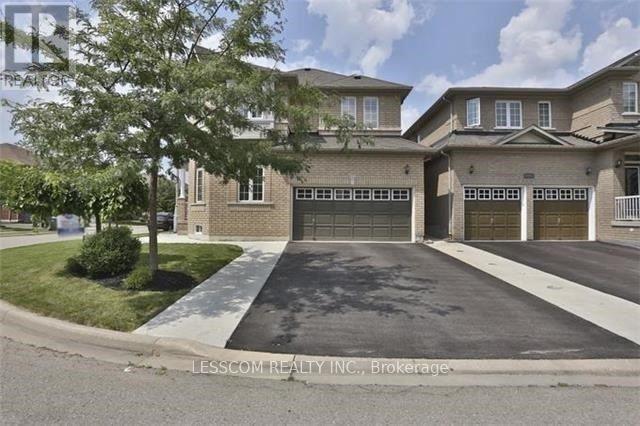 A real estate image of a house with a driveway and garage doors.