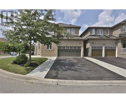 A real estate image of a house with a driveway and garage doors.