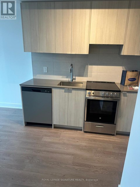 A modern kitchen with a stainless steel oven and wooden cabinets.