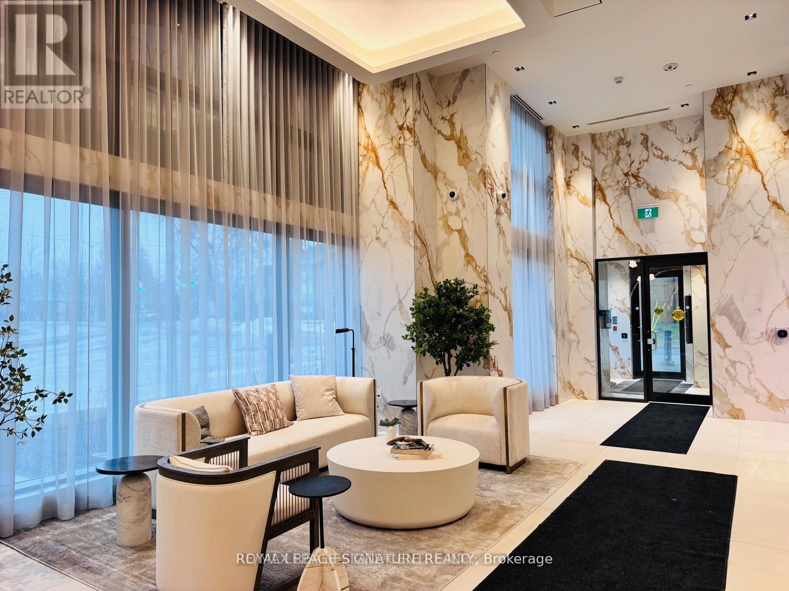 A living room with a marble wall and a black and white rug.