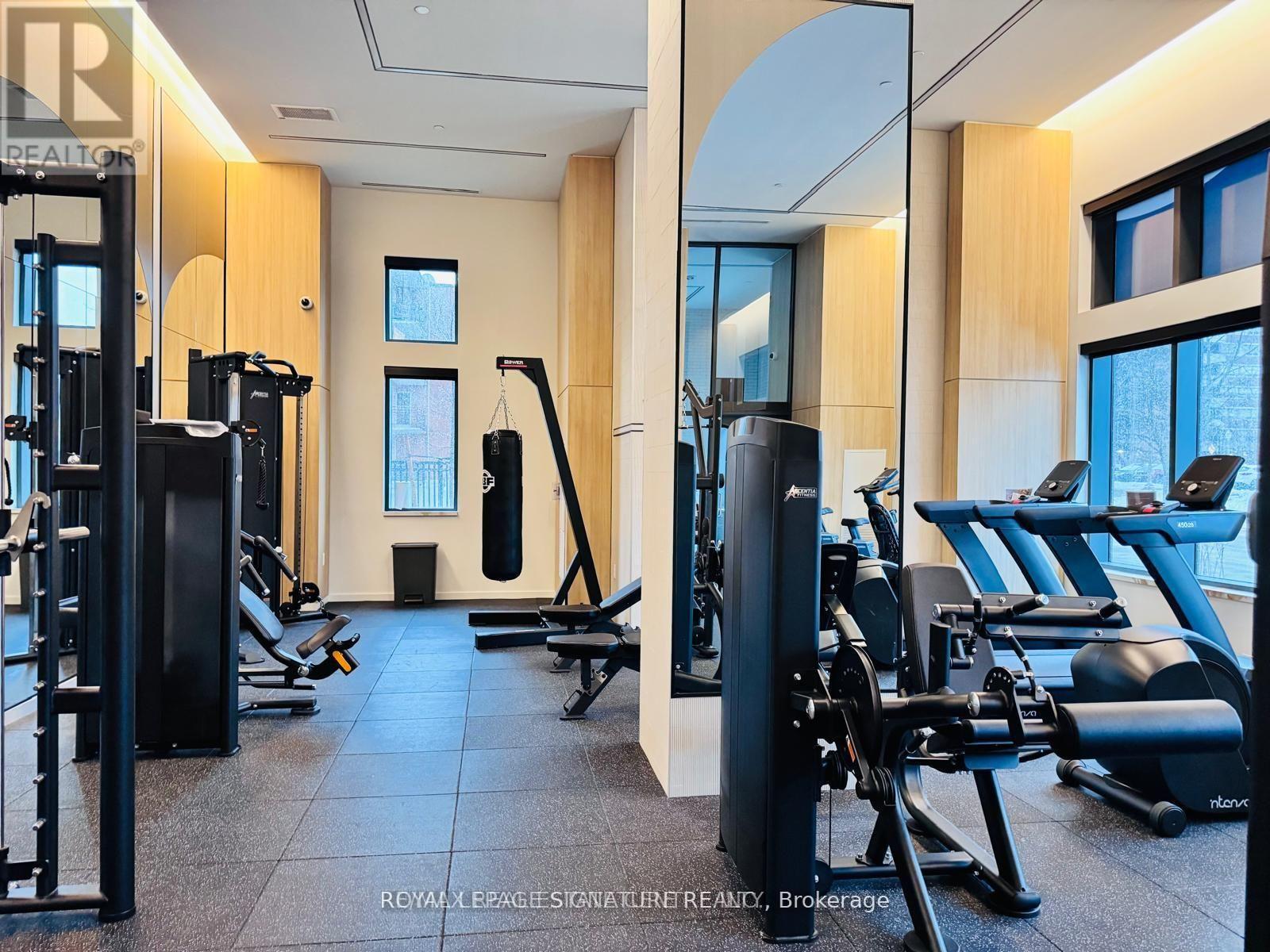 A gym with a variety of equipment including treadmills, weights, and exercise machines.