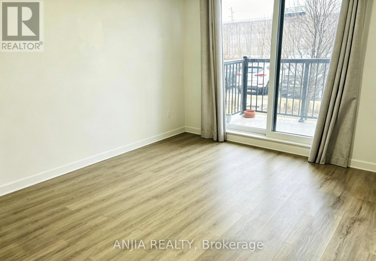 A room with a sliding glass door leading to a balcony.