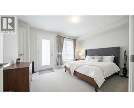 A bedroom with a large bed, a wooden dresser, and a window with curtains.