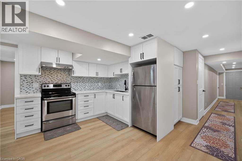 A modern kitchen with white cabinets and stainless steel appliances.