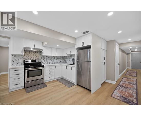A modern kitchen with white cabinets and stainless steel appliances.