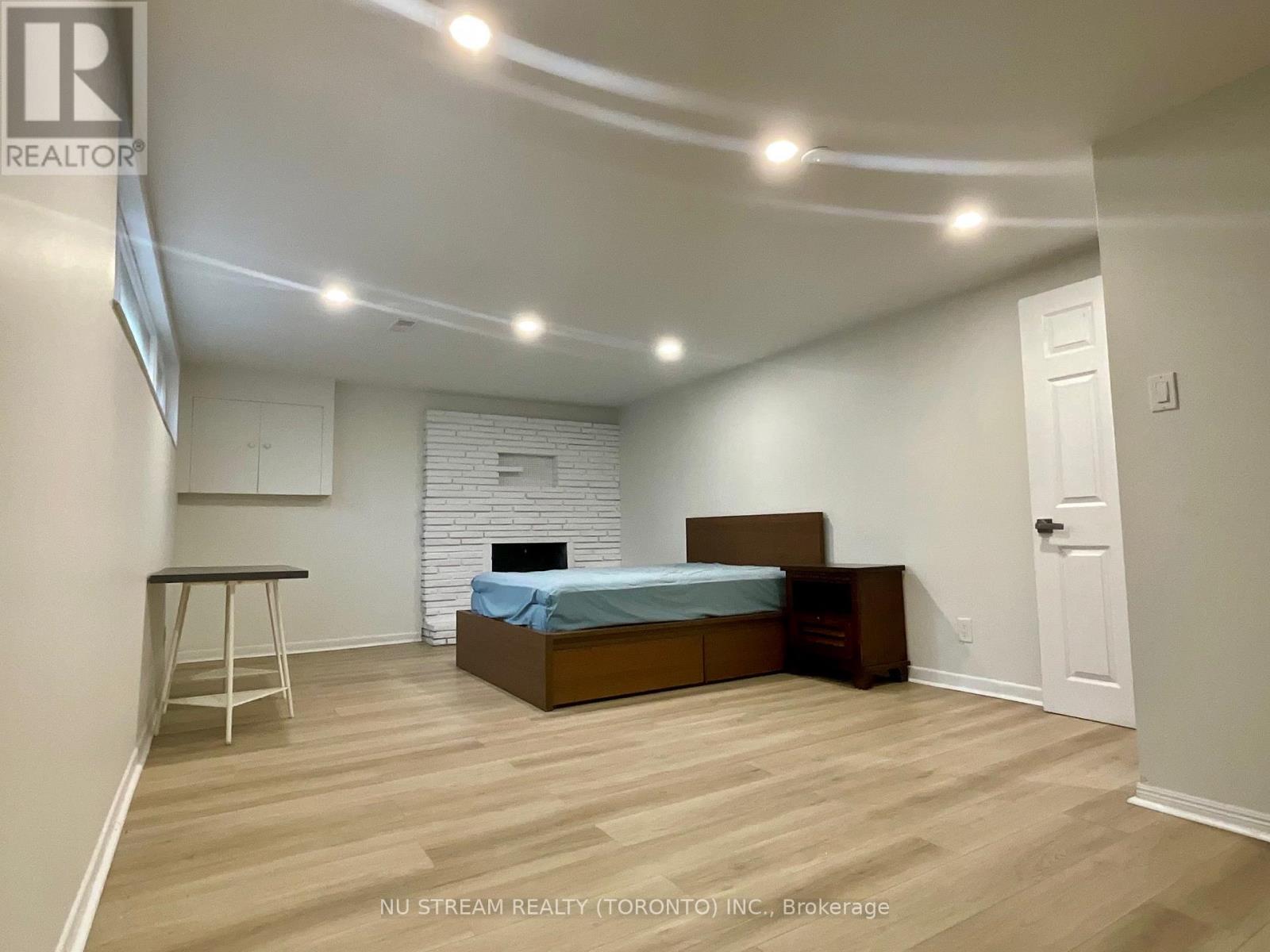 A bedroom with a bed, nightstand, and a table.