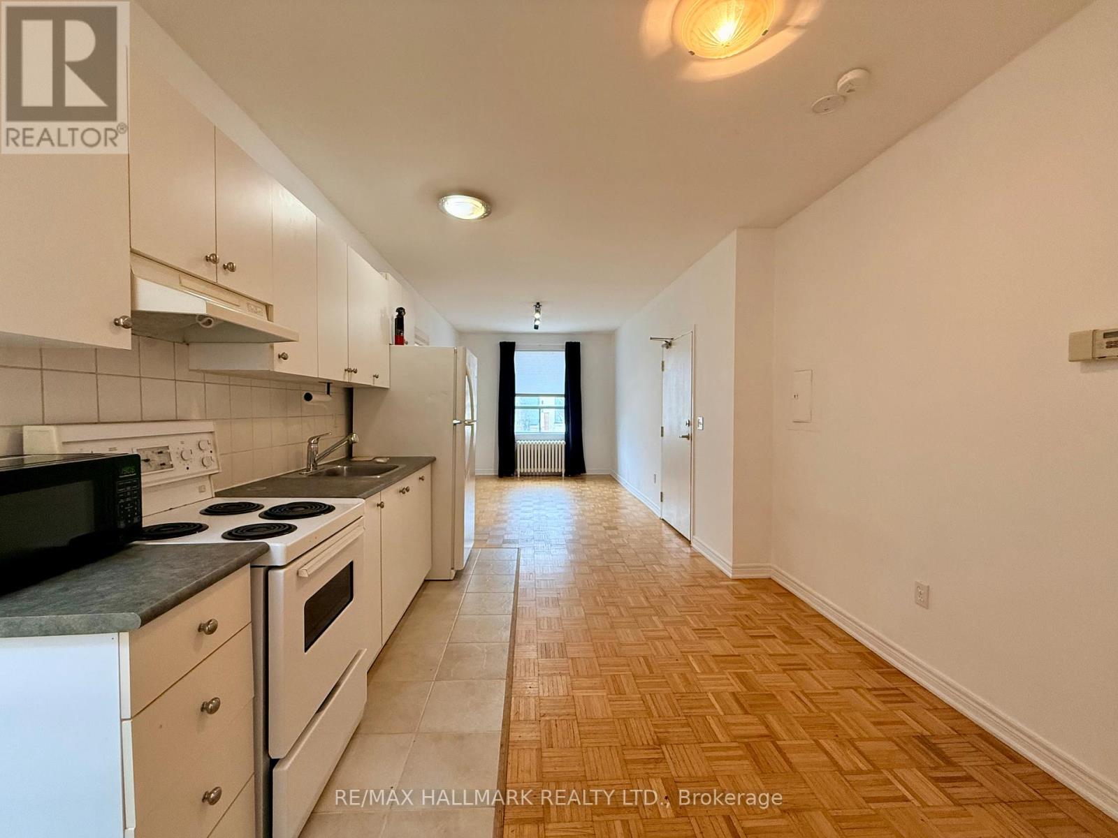A kitchen with white cabinets and a black countertop.