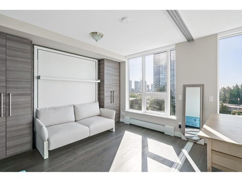 A modern living room with a white sofa and a large window.