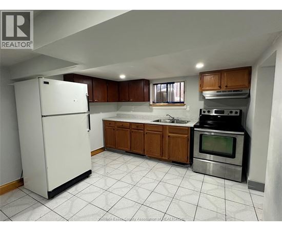 A kitchen with white appliances and wooden cabinets.