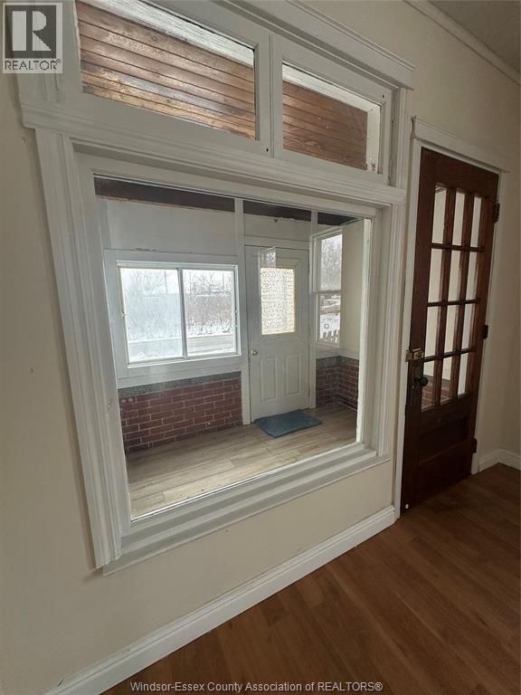 A room with a large window and a wooden floor.