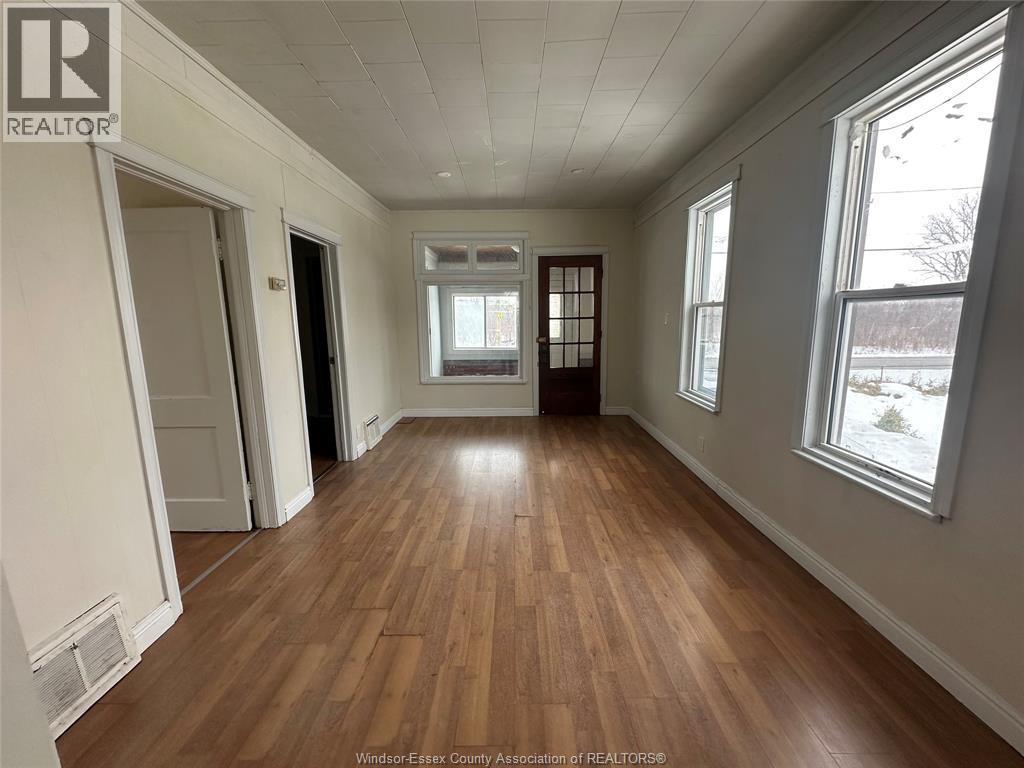 A room with wooden flooring and white walls.