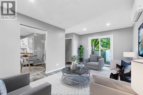 A living room with a grey couch and a glass coffee table.